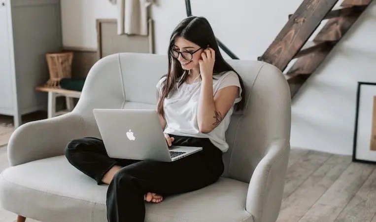 Person smiling at a laptop while learning a new language