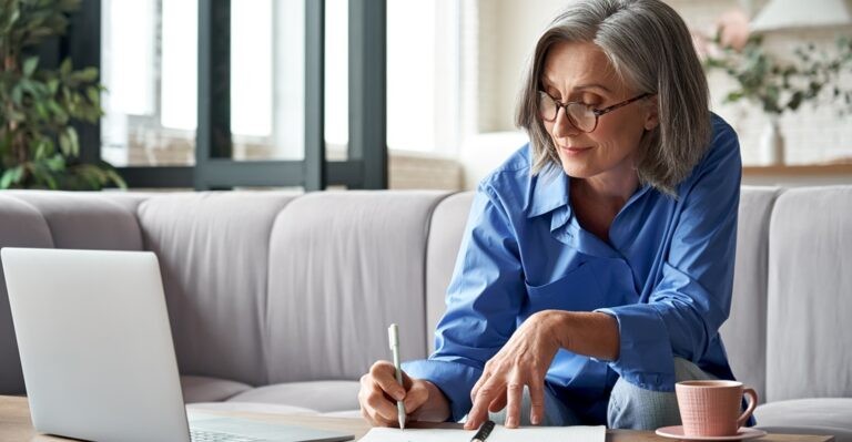 Adult female student is learning German capitalization rules while sitting at desk with laptop