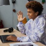 Happy school boy greeting teacher on laptop