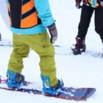 Instructor giving snowboard lesson