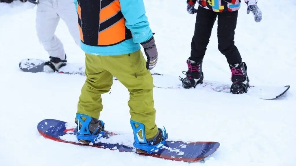 Instructor giving snowboard lesson