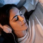 Man listening to Spanish lessons with headphones while sleeping