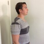 A person standing tall with a straight posture, showcasing ideal singing alignment.