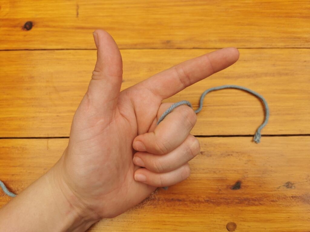 Grab the yarn with three fingers and point your index finger outward