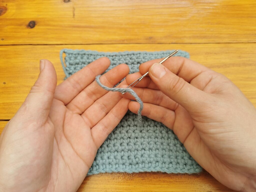 Pull the yarn through the eye of the needle
