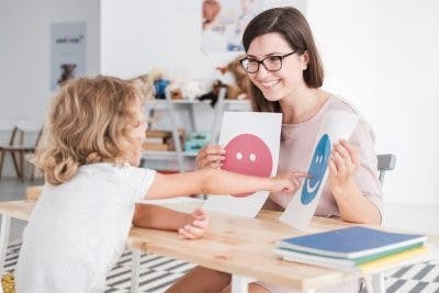 Teacher assisting a child with learning difficulties, representing teaching children with cerebral palsy learning difficulties