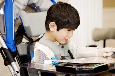 Teacher assisting a child, representing teaching children with cerebral palsy