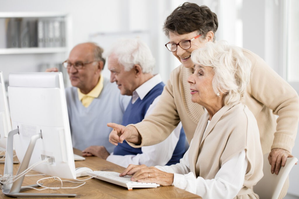 An older woman helps a younger woman with a computer issue