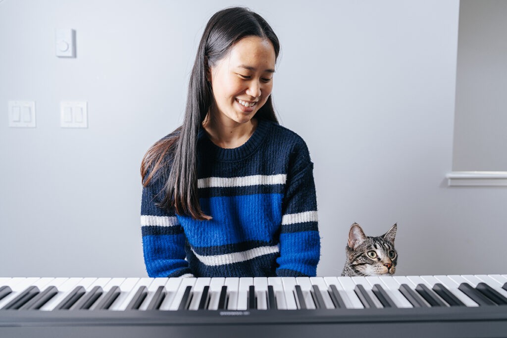 Woman with cat practicing piano