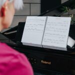 Woman reading sheet music while playing piano