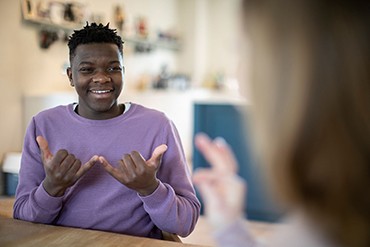 A teenage boy having a conversation using sign language