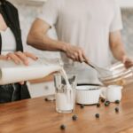 person using non-dominant hand to pour milk