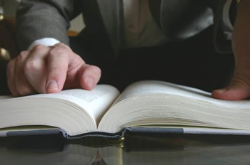 Student reading a book with assistance