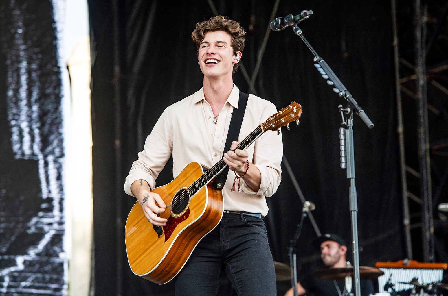 Young Shawn Mendes playing guitar, capturing the early stages of his music career fueled by social media and talent.
