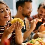 Young woman enjoying a taco and practicing Spanish food terms