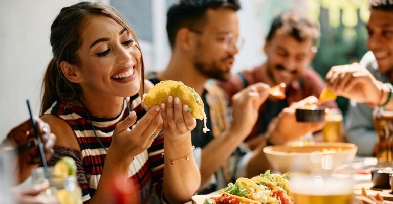 Young woman enjoying a taco and practicing Spanish food terms