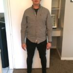 Man standing with tall posture in front of a door