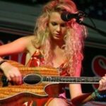 Young Taylor Swift learning guitar with her mother nearby