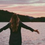 A woman with her hands raised in prayer, symbolizing the practice of speaking in tongues and spiritual connection.