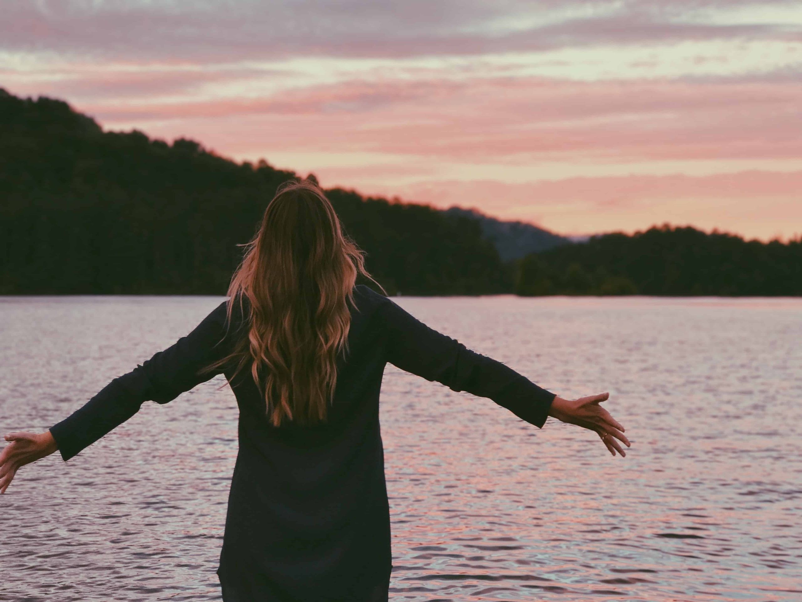 A woman with her hands raised in prayer, symbolizing the practice of speaking in tongues and spiritual connection.