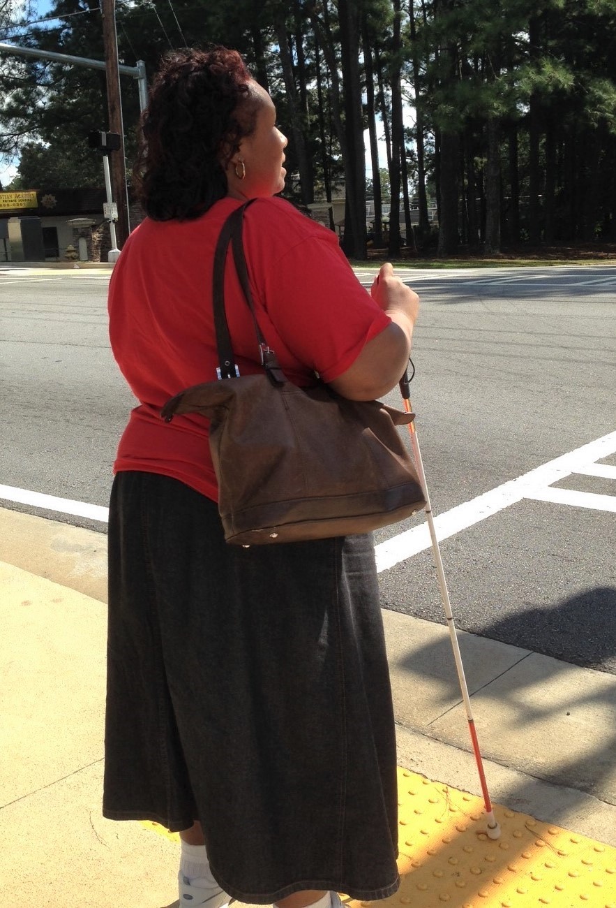 Empish Holding White Cane at Street Intersection