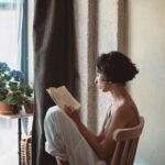 Adult reading a book in a cozy setting, symbolizing lifelong learning and personal growth