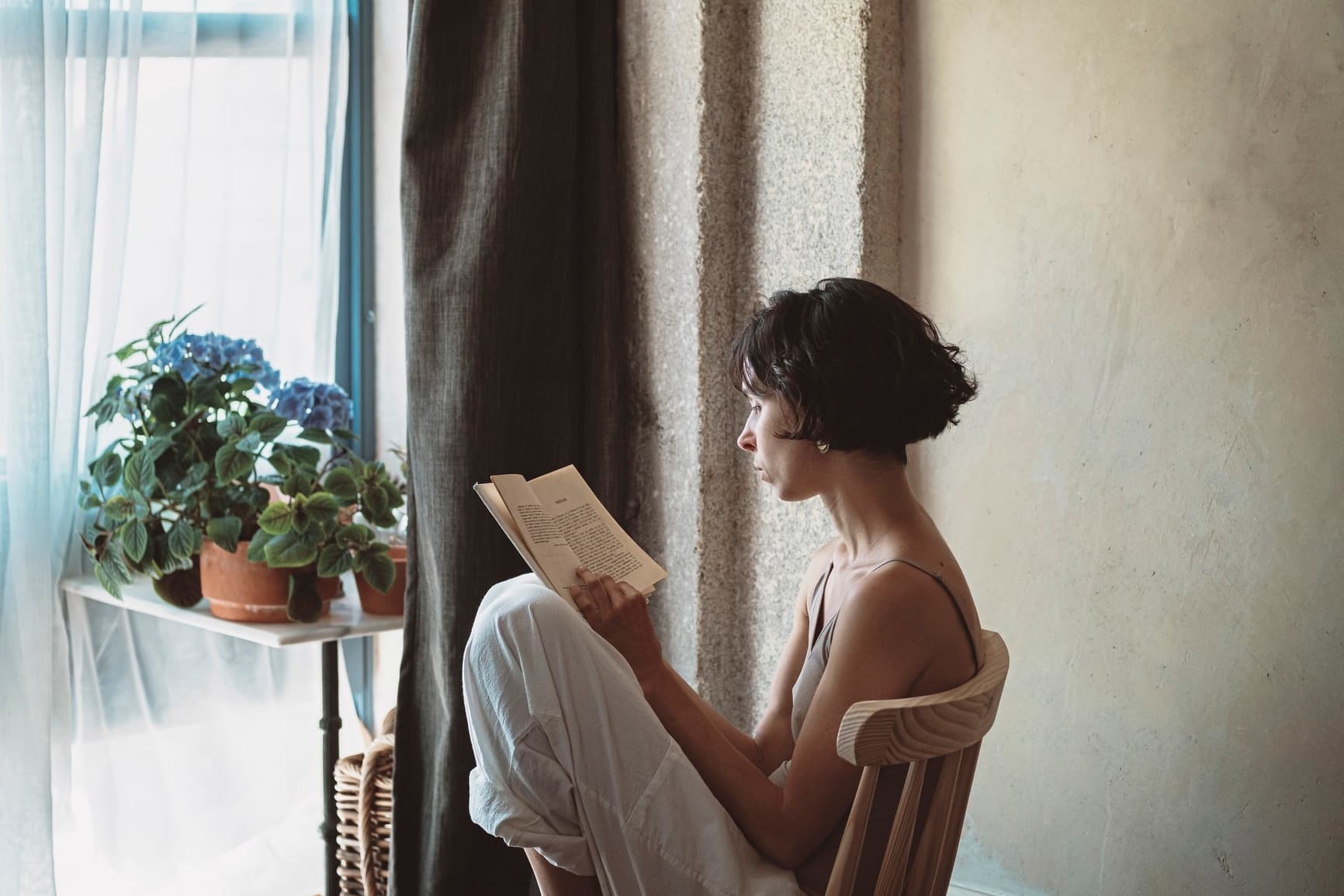 Adult reading a book in a cozy setting, symbolizing lifelong learning and personal growth