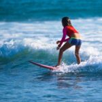 Surfer riding a wave, demonstrating balance and skill